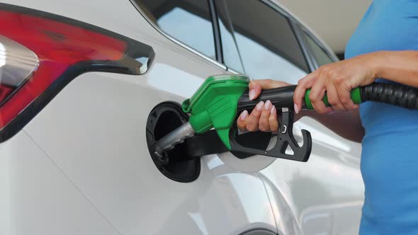 Woman Pulls Out a Refueling Gun From a Car Tank After Finishing Refueling