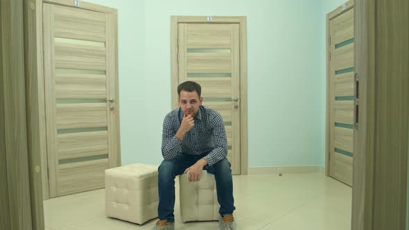 Male Patient Waiting for Doctor's Appointment Nodding His Head and Looking Into the Camera