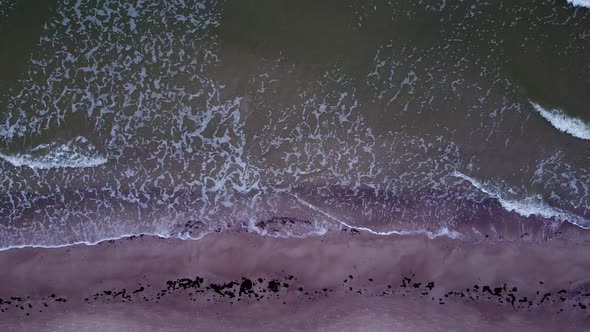 Beautiful aerial view of an old wooden pier at the Baltic sea coastline, overcast day, white sand be