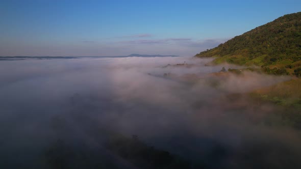 4K Aerial view of the misty sunrise in the forest. Tropical Rainforest in Thailand
