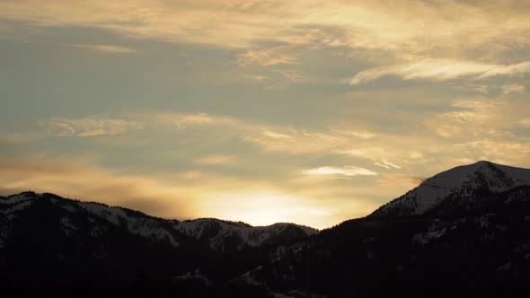 Beautiful sunset over snowy mountains with the Idaho pass during golden hour in Wyoming United State