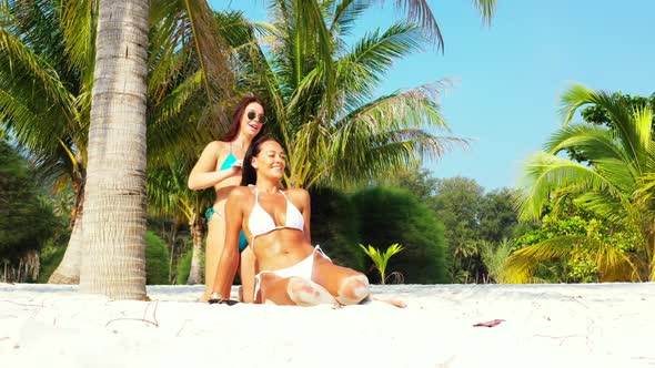Ladies together best friends on paradise shore beach lifestyle by clear lagoon and white sandy backg