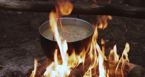 Old Retro Camp Saucepan Boiled Water For Soup Preparation On A Fire In Forest. Flame Fire Bonfire At