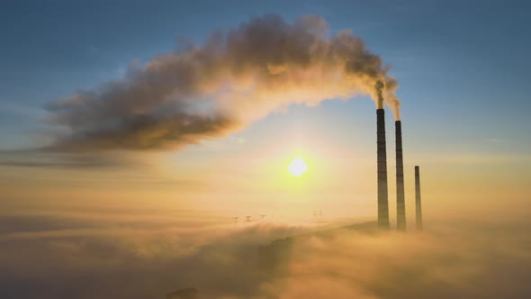 Aerial View of Coal Power Plant High Pipes with Black Smoke Moving Up Polluting Atmosphere at Sunset