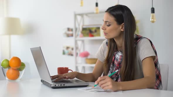 Young Woman Working on Laptop at Home, Paying Utility Bills Online, Budget