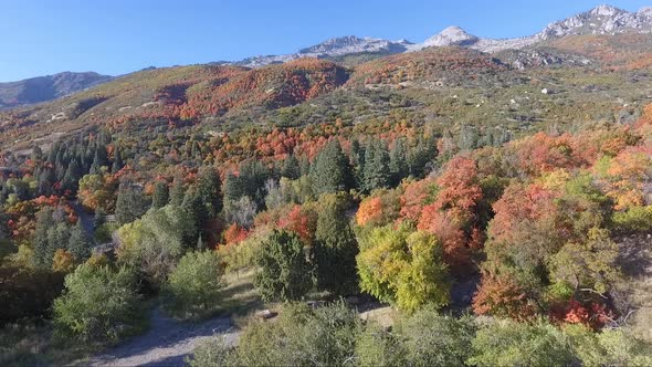 A drone flies over the rocks and slopes of  Dry Creek Trailhead in Alpine, Utah as leaves change int