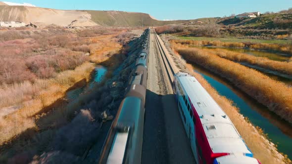 AERIAL - Trains on railroad tracks near Bluffdale, Utah, forward tracking