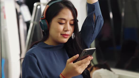 Young Woman Using Mobile Phone on Public Train