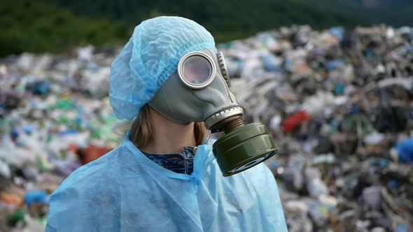 Woman wearing a gas mask on a landfill, a lot of garbage, an ecological catastrophe