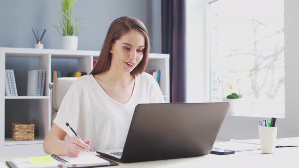 Young Woman Works at Home Office Using Computer.