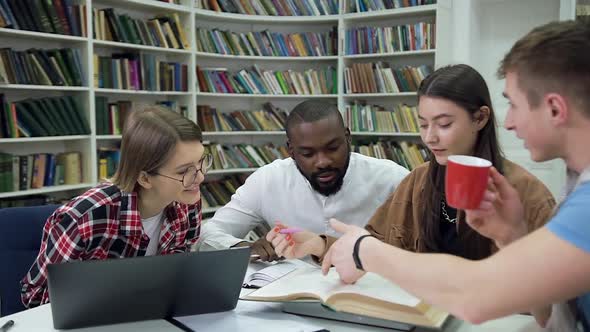 Students Sitting Together in the Library and Working Over Hometask