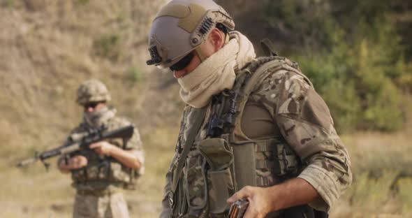 Male Soldier Reloading Firearm During War