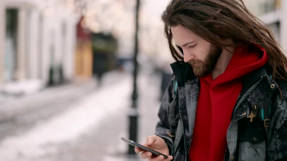 Trendy Male City Dweller with Smartphone on Street of Town in Winter Internet and Social Media