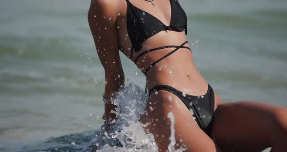 Woman in Bikini Sitting on the Stone at the Beach Slow Motion