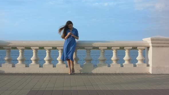 Smiling Girl in Blue Dress Texting Message