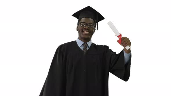 Happy African American Male Student in Graduation Robe Walking with Diploma and Talking To Camera on