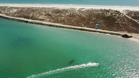 Man Engaged in Extreme Sports By Riding on Water Board with Parachute on Wave