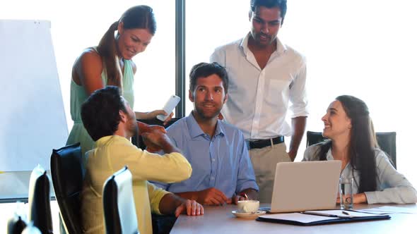 Businesspeople having a discussion while using laptop