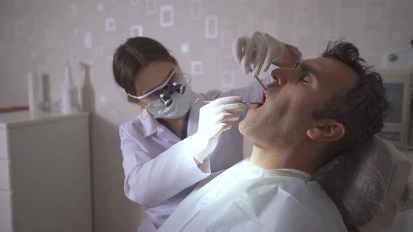 The dentist checks the patient's teeth.