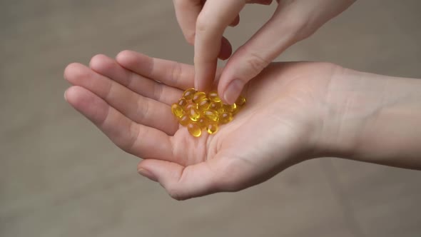 Vitamin Omega-3 or Vitamin D in a female hand close-up.