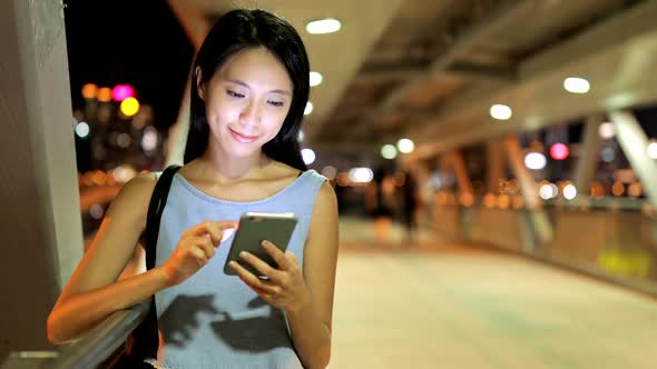 Woman using mobile phone at night 