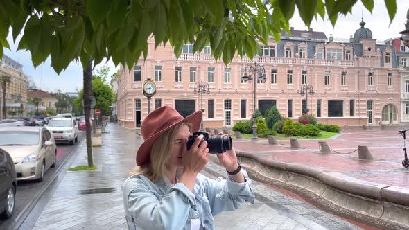 Photographer Takes a Pictures on Camera in the City