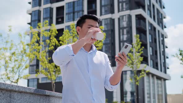 Focused Chinese Young Businessman Texting Email Surfing Internet in City