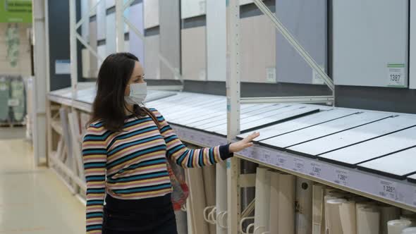 Female Choosing Wallpapers in Building Store