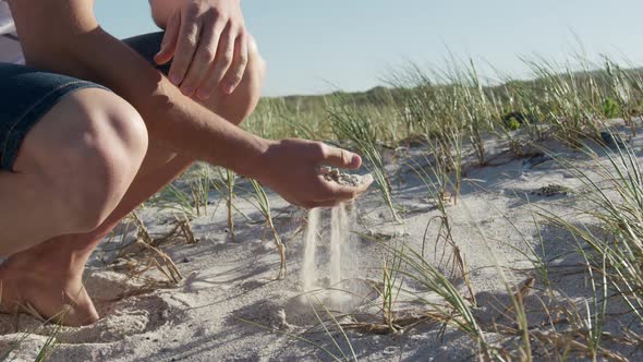 Man crouching on the beach