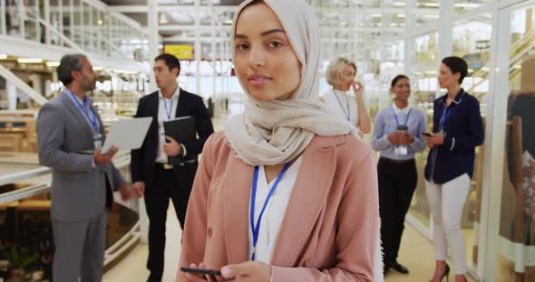 Businesswoman holding smartphone in a conference foyer