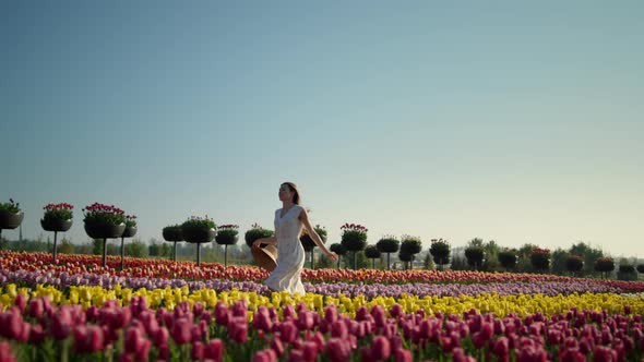 Young Woman Running in Tulip Field