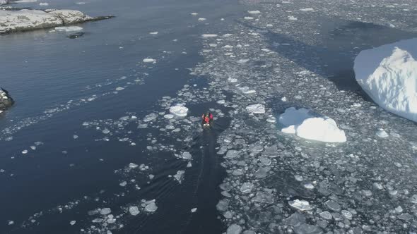 Polar Explorers in Motor Boat Sail Between Icebergs. Dangerous - People Afraid