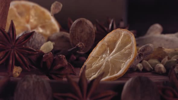 Lemon Slice and Different Spices Falling on Wood