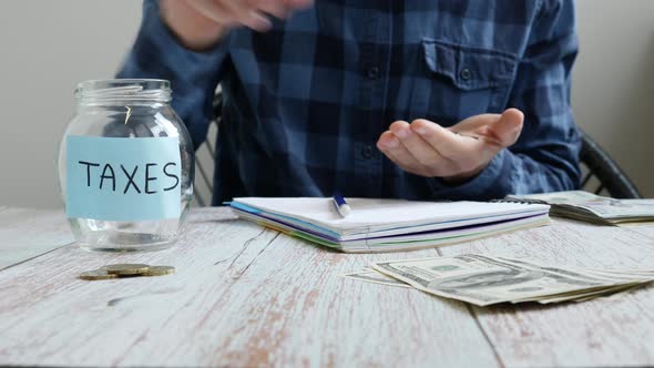 Man analyzing monthly budget, saving money coins for unpaid taxes