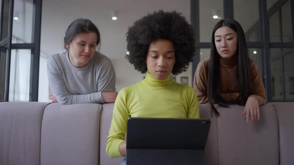 Middle Shot of Young Beautiful African American Woman Typing on Tablet Keyboard with Dissatisfied