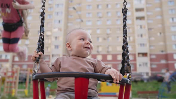 A Baby Girl in the Swing for the First Time in Life Has a Lot of Fun