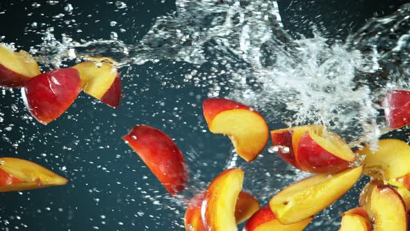 Super Slow Motion Shot of Flying Fresh Peach Slices and Water Side Splash at 1000Fps