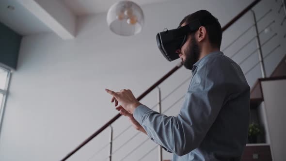 Man Is Standing in Center of Living Room and Typing Information Using Digital Technology