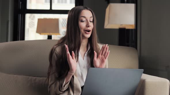 Beautiful Businesswoman Using Laptop for Video Call Online in Hotel Lounge