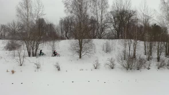 two guys riding motorcycles in the snow