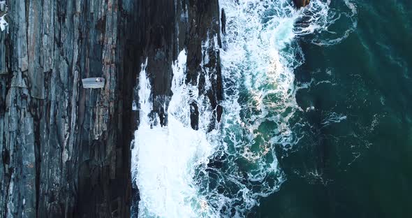 A man watching the waves hit the rocks down below in Curtis island lighthouse Camden Maine USA