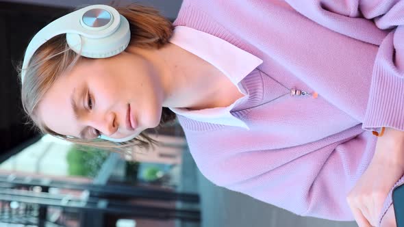 Melancholic Lady Student in Earphones Listens to Music