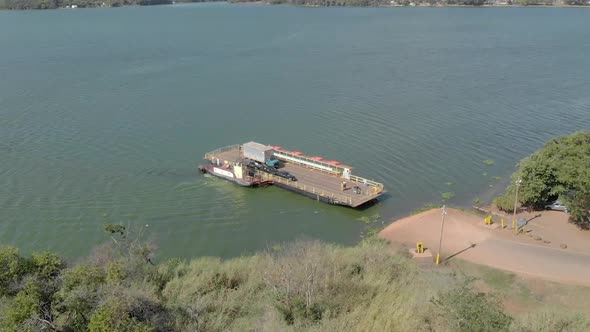 Boat crosses cars from one side of the river to the other. Transport ferry