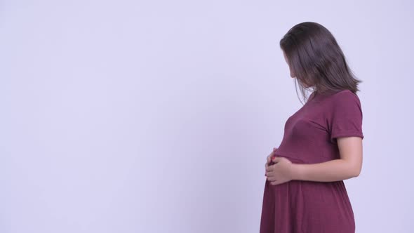 Profile View of Happy Young Beautiful Pregnant Woman Pointing Finger