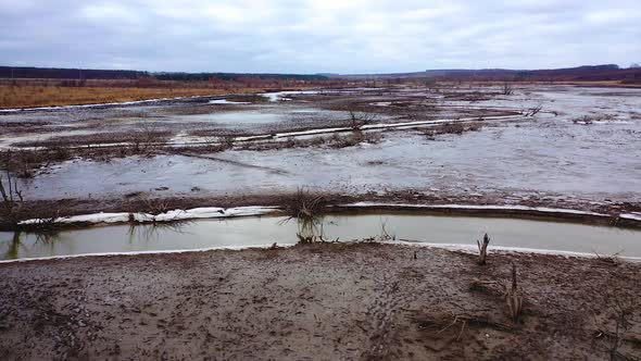 Nature in danger. Drought on earth. Narrow stream of dirty water of dried lake. Climate change.