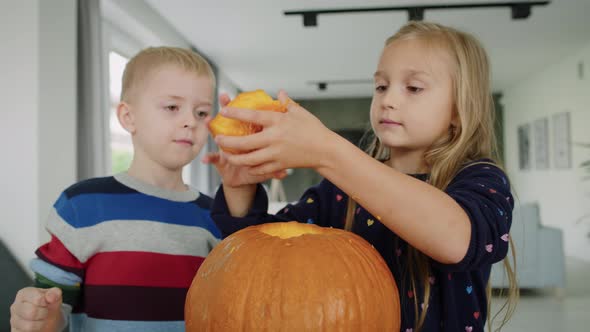 Handheld view of drilled pumpkin and curious children