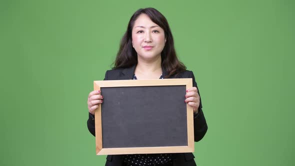 Mature Beautiful Asian Businesswoman Showing Blackboard