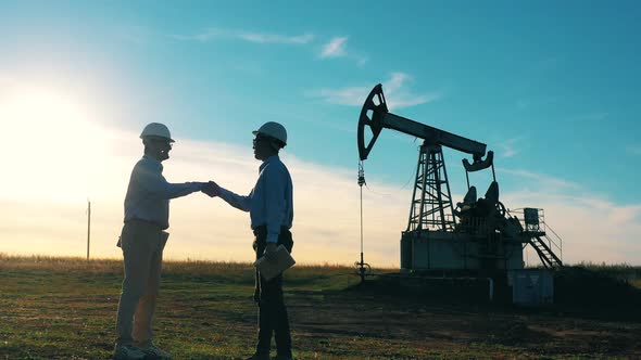 Two Workers Handshake Agreement at Oil Field