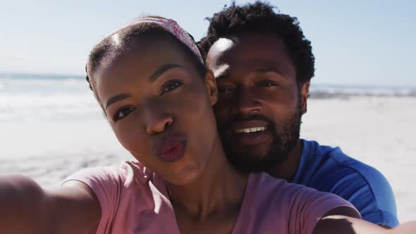 Portrait of african american couple smiling to camera on the beach