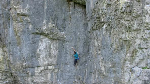 Aerial view of a man rock climbing up a mountain